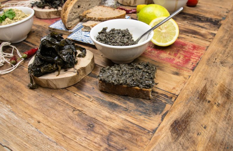 Leckere Gerichte aus frischen Algen auf einem Holztisch angerichtet. 